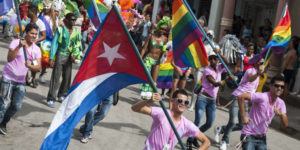 Marchers carry the Cuban and LGBT rainbow flags